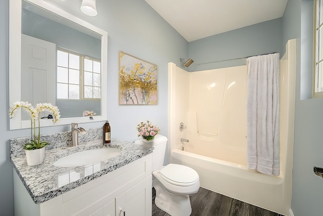 full bathroom featuring toilet, vanity, hardwood / wood-style floors, and washtub / shower combination