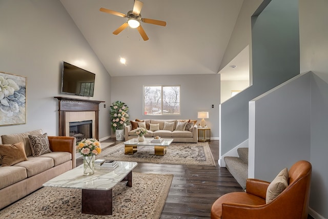 living room featuring ceiling fan, dark hardwood / wood-style flooring, a fireplace, and high vaulted ceiling