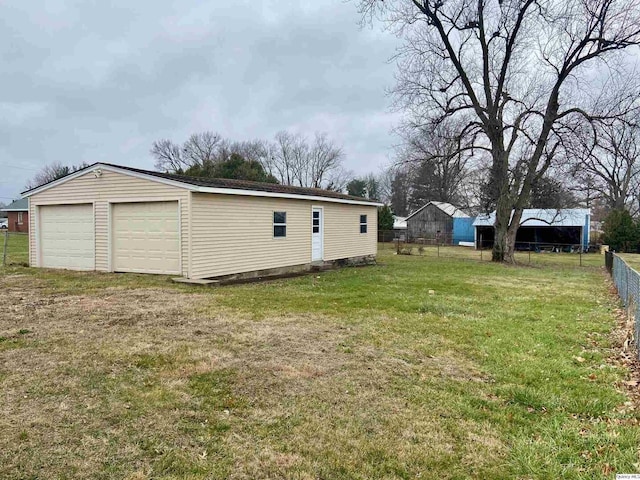 view of yard featuring a garage and an outbuilding