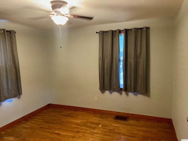 spare room with hardwood / wood-style floors and ceiling fan