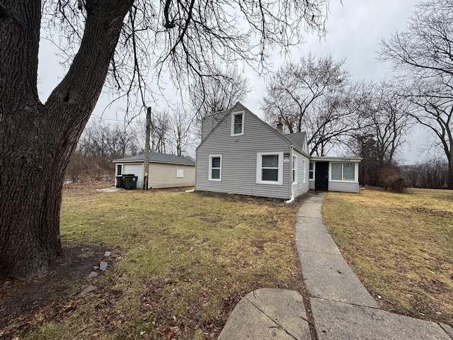 view of front of property featuring a front lawn, an outdoor structure, and a garage