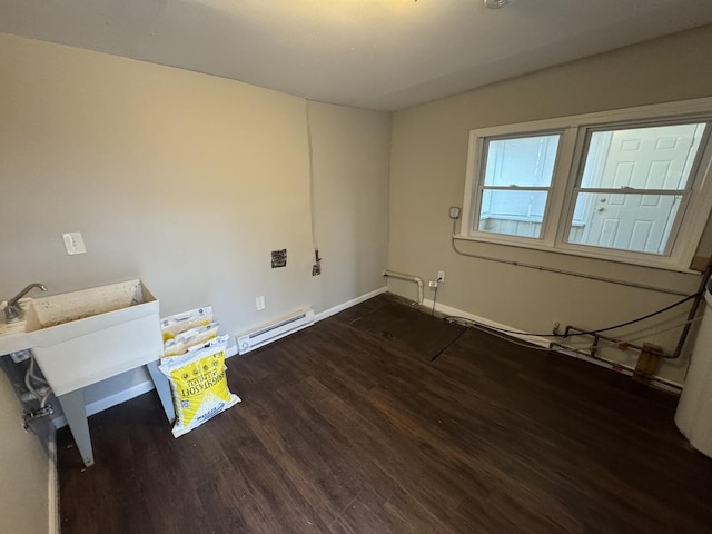 spare room with dark wood-type flooring and a baseboard heating unit