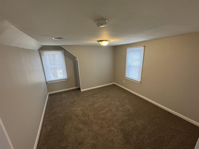 bonus room featuring dark carpet and lofted ceiling