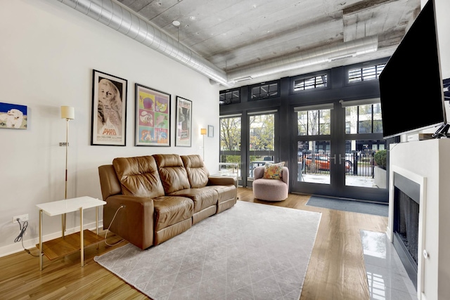 living room featuring light hardwood / wood-style flooring and a towering ceiling