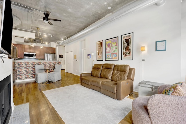 living room featuring light wood-type flooring and ceiling fan