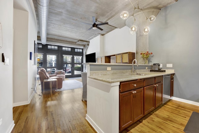 kitchen featuring ceiling fan, kitchen peninsula, sink, and light hardwood / wood-style flooring