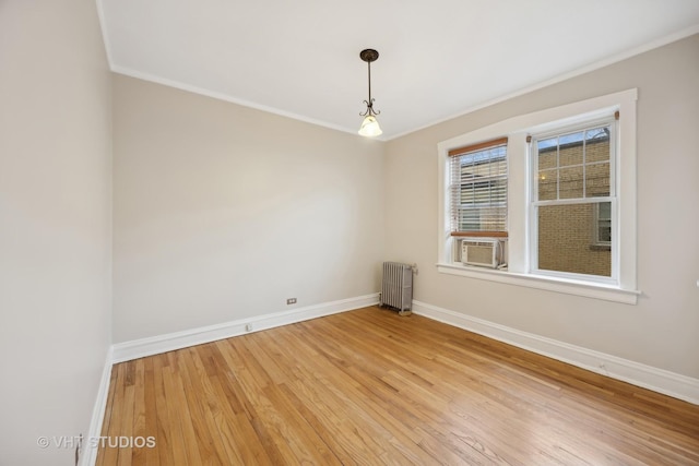 spare room with crown molding, wood-type flooring, radiator, and cooling unit