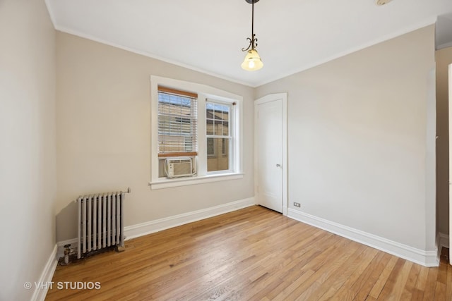 spare room with light hardwood / wood-style flooring, cooling unit, radiator heating unit, and ornamental molding