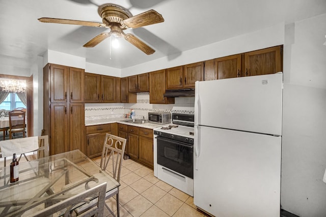 kitchen featuring backsplash, ceiling fan with notable chandelier, white appliances, sink, and light tile patterned flooring