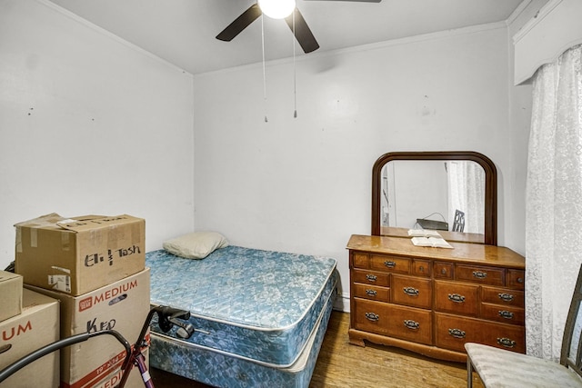 bedroom with light wood-type flooring, ceiling fan, and crown molding