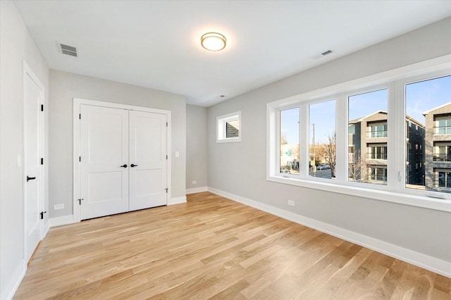 unfurnished bedroom with light hardwood / wood-style flooring and a closet