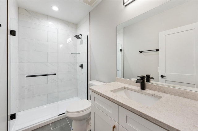 bathroom with tile patterned flooring, vanity, toilet, and a shower with shower door