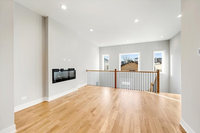 unfurnished living room featuring plenty of natural light and light wood-type flooring