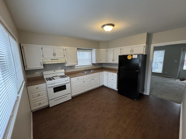 kitchen featuring white gas stove, black refrigerator, white cabinets, and sink