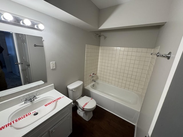 full bathroom with vanity, tiled shower / bath combo, hardwood / wood-style flooring, and toilet