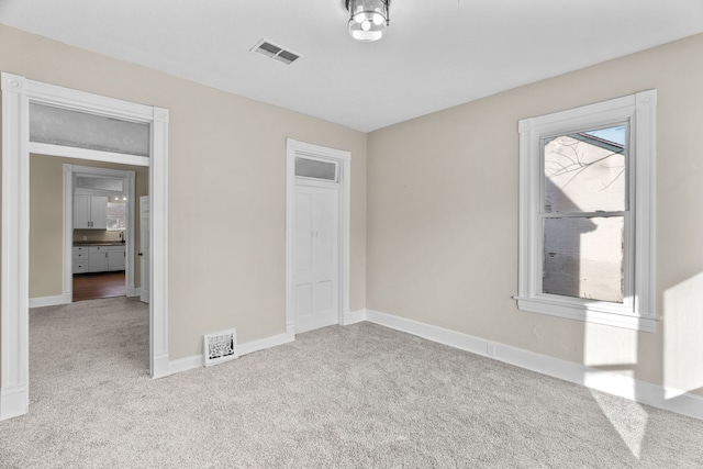 unfurnished bedroom featuring light carpet