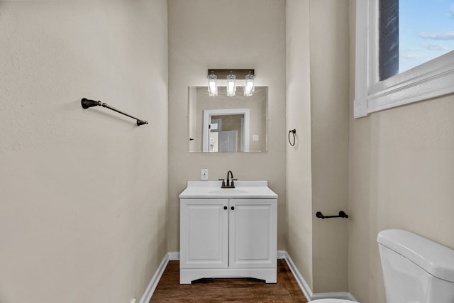 bathroom with vanity, toilet, and wood-type flooring