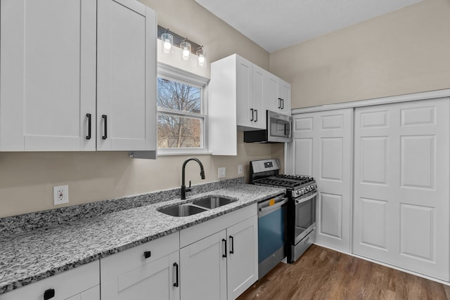 kitchen with white cabinets, light stone countertops, sink, and stainless steel appliances