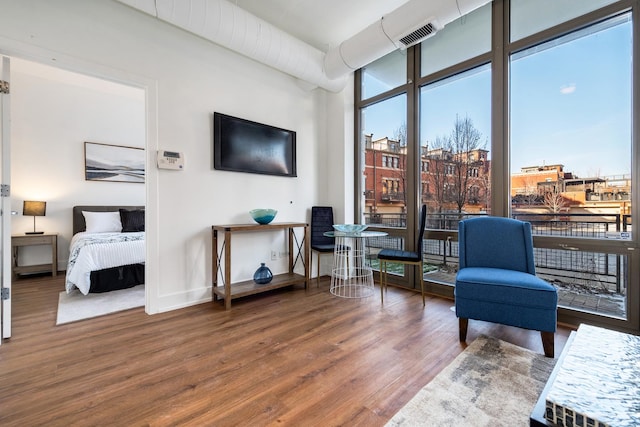 sitting room with floor to ceiling windows and hardwood / wood-style floors