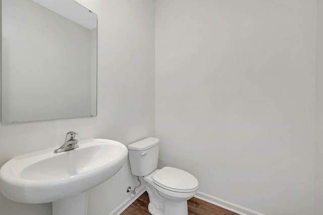 bathroom featuring hardwood / wood-style flooring, toilet, and sink