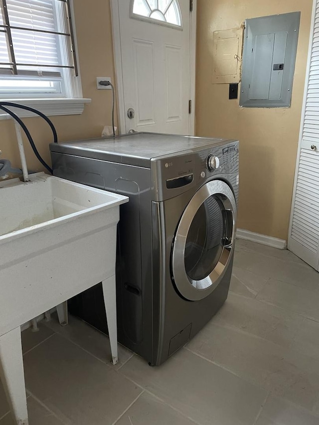 clothes washing area featuring washer / clothes dryer, light tile patterned floors, and electric panel