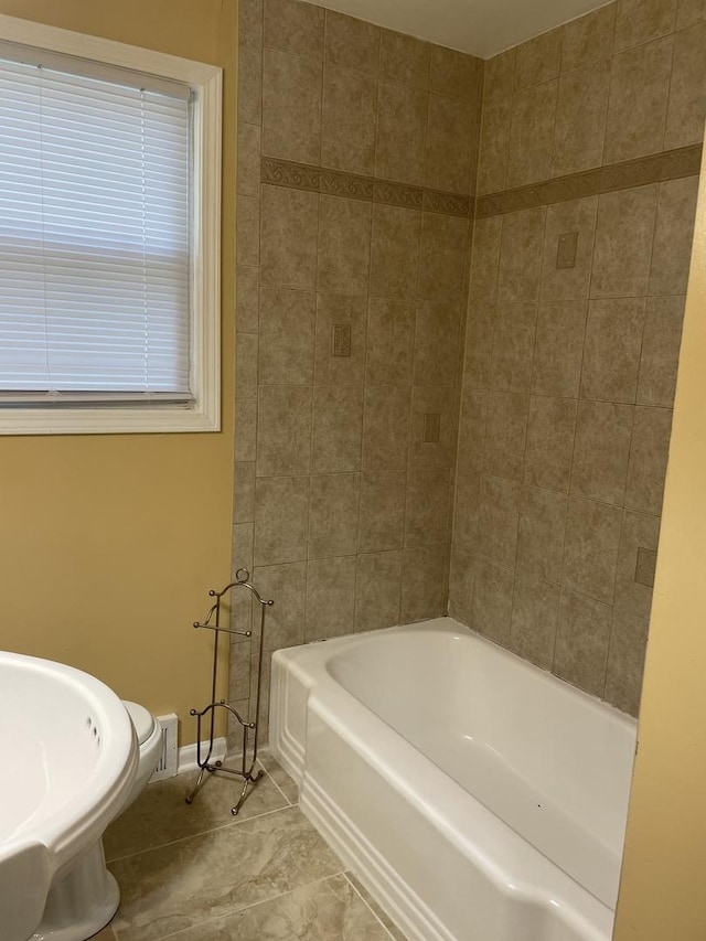 bathroom with a tub to relax in and tile patterned flooring