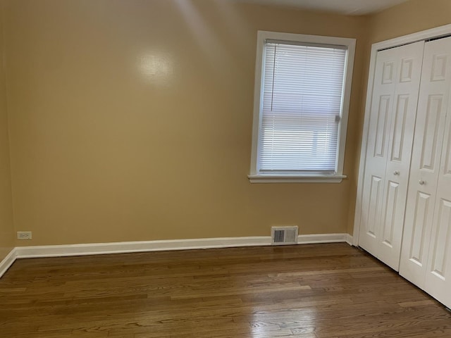 unfurnished bedroom with hardwood / wood-style floors and a closet