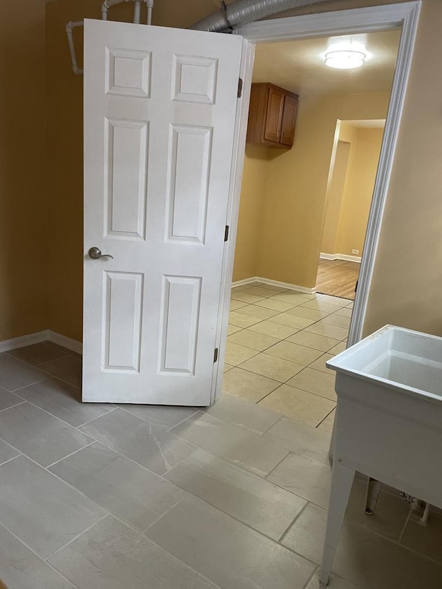 hall with light tile patterned floors and sink