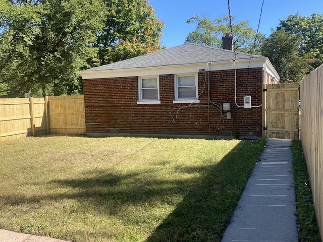 view of side of home with a yard