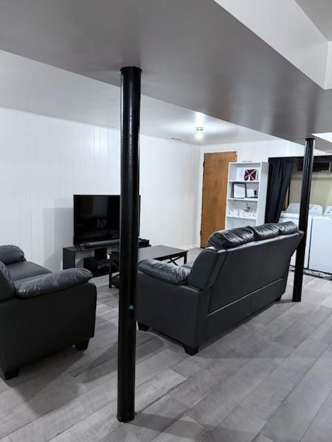 living room with washer and dryer and hardwood / wood-style flooring