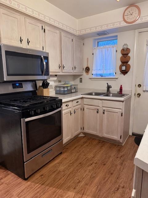 kitchen featuring light wood-type flooring, sink, and appliances with stainless steel finishes