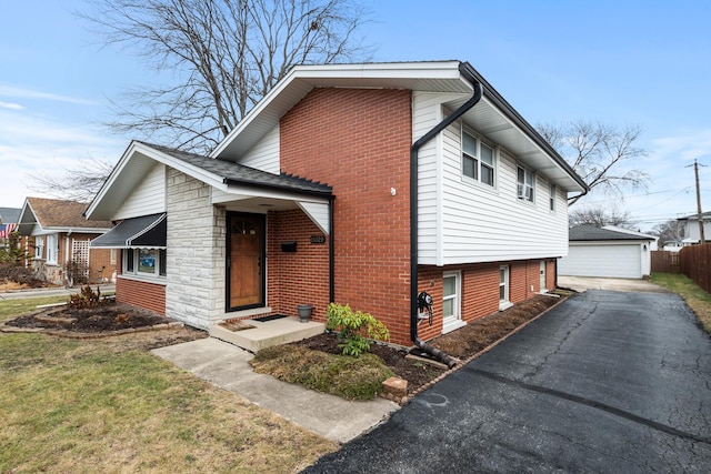 view of front of home featuring a garage, an outbuilding, and a front lawn