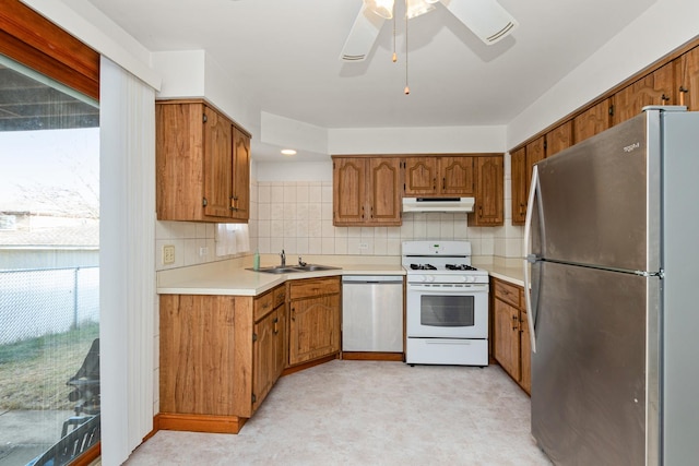 kitchen featuring backsplash, ceiling fan, sink, and stainless steel appliances