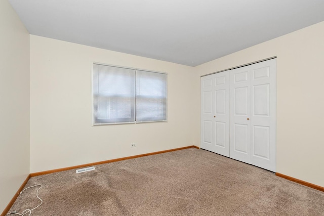 unfurnished bedroom with carpet flooring and a closet