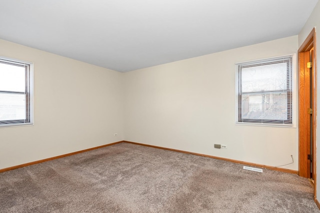 empty room with plenty of natural light and carpet