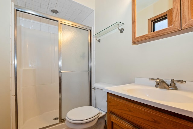 bathroom featuring vanity, toilet, and a shower with shower door