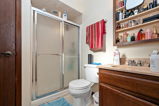 bathroom featuring tile patterned floors, vanity, toilet, and a shower with shower door