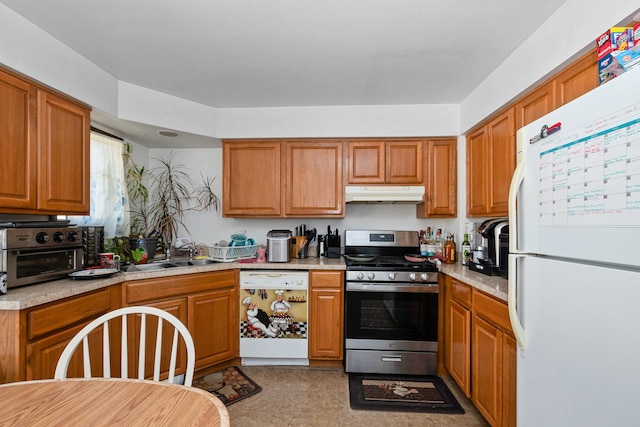 kitchen featuring light stone countertops, white appliances, and sink