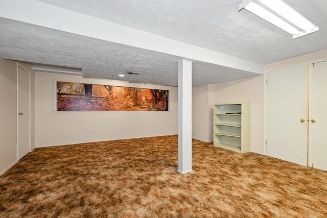 basement featuring carpet floors and a textured ceiling