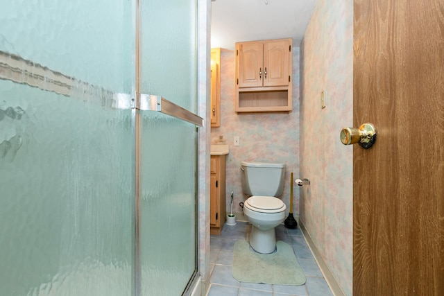 bathroom featuring tile patterned floors, vanity, toilet, and a shower with shower door