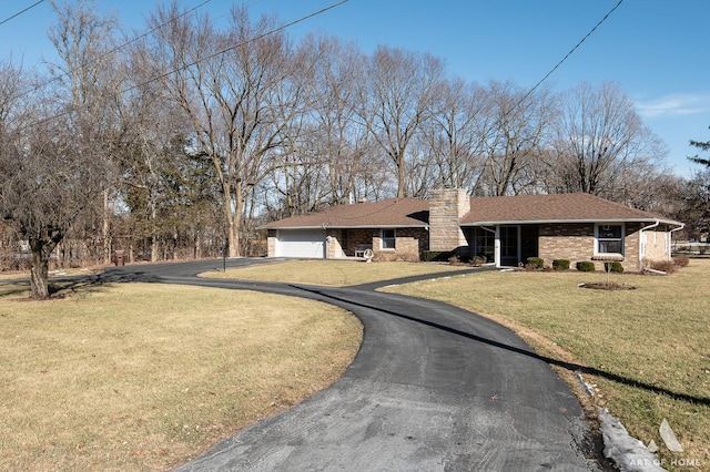 view of front of house featuring a garage and a front lawn