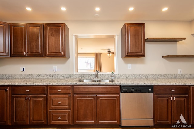 kitchen with light stone counters, stainless steel dishwasher, ceiling fan, and sink