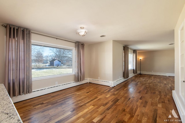 spare room with dark wood-type flooring and a baseboard radiator