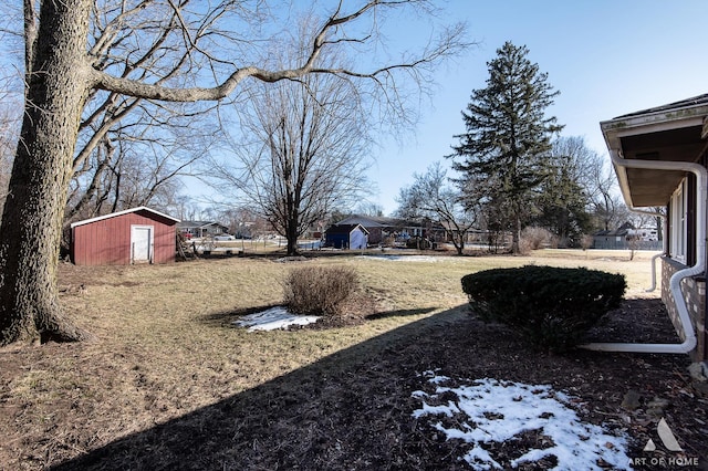 yard covered in snow with a storage shed