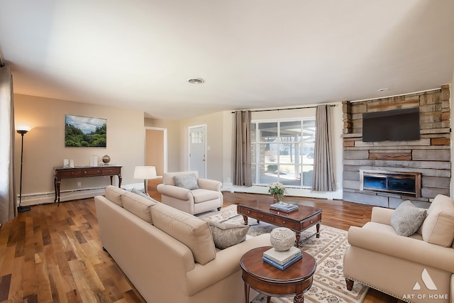 living room featuring hardwood / wood-style flooring, a baseboard radiator, and a fireplace