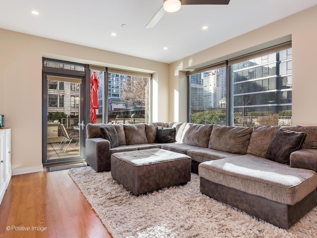 living room featuring ceiling fan and light hardwood / wood-style floors