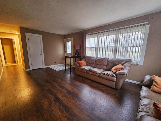 living room featuring a textured ceiling and dark wood-type flooring