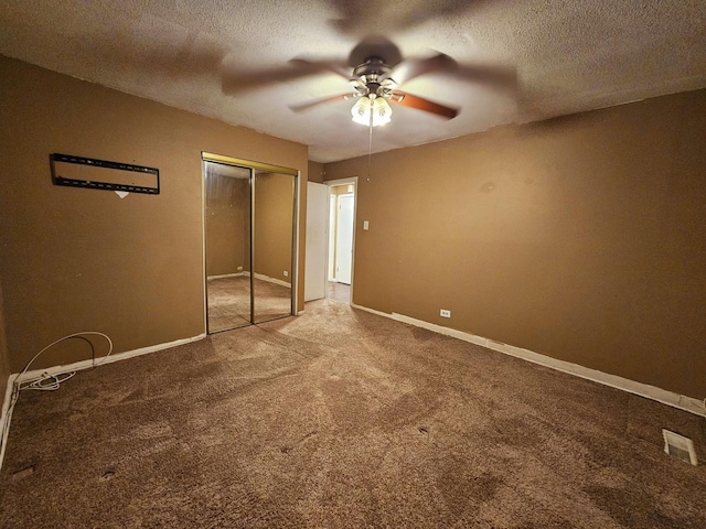 unfurnished bedroom with ceiling fan, carpet floors, a textured ceiling, and a closet