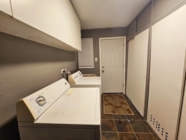 laundry room with washer and dryer, cabinets, and dark tile patterned floors