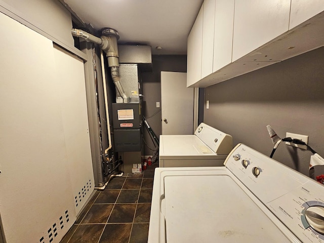 clothes washing area featuring cabinets and separate washer and dryer